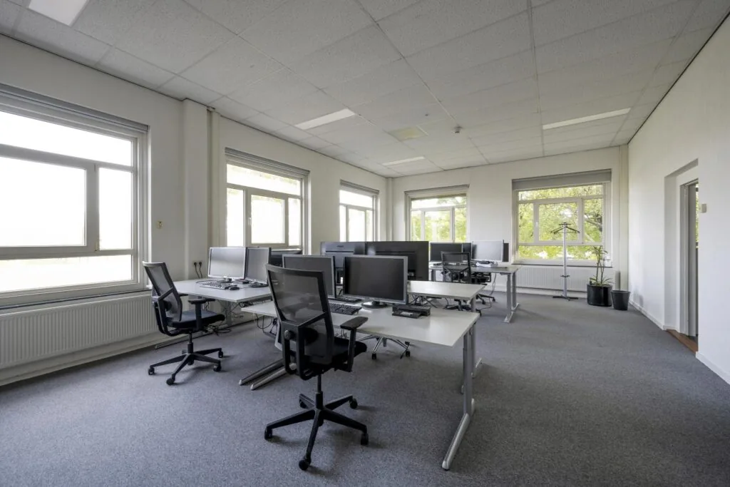 Modern en licht kantoor aan de Van der Madeweg met meerdere werkplekken en grote ramen.