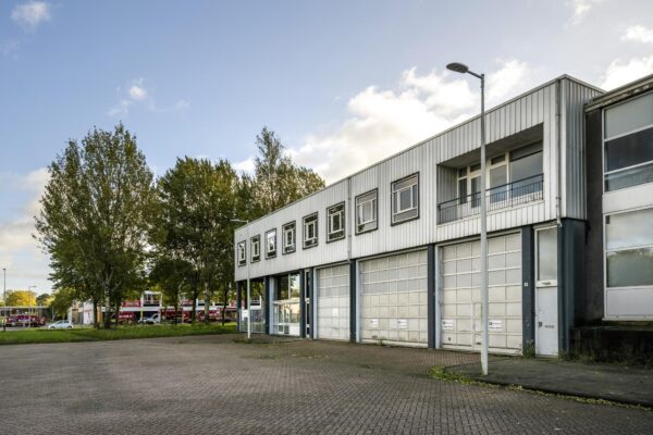 Grijs industriepand met bovenramen en meerdere garagepoorten aan de Van der Madeweg.