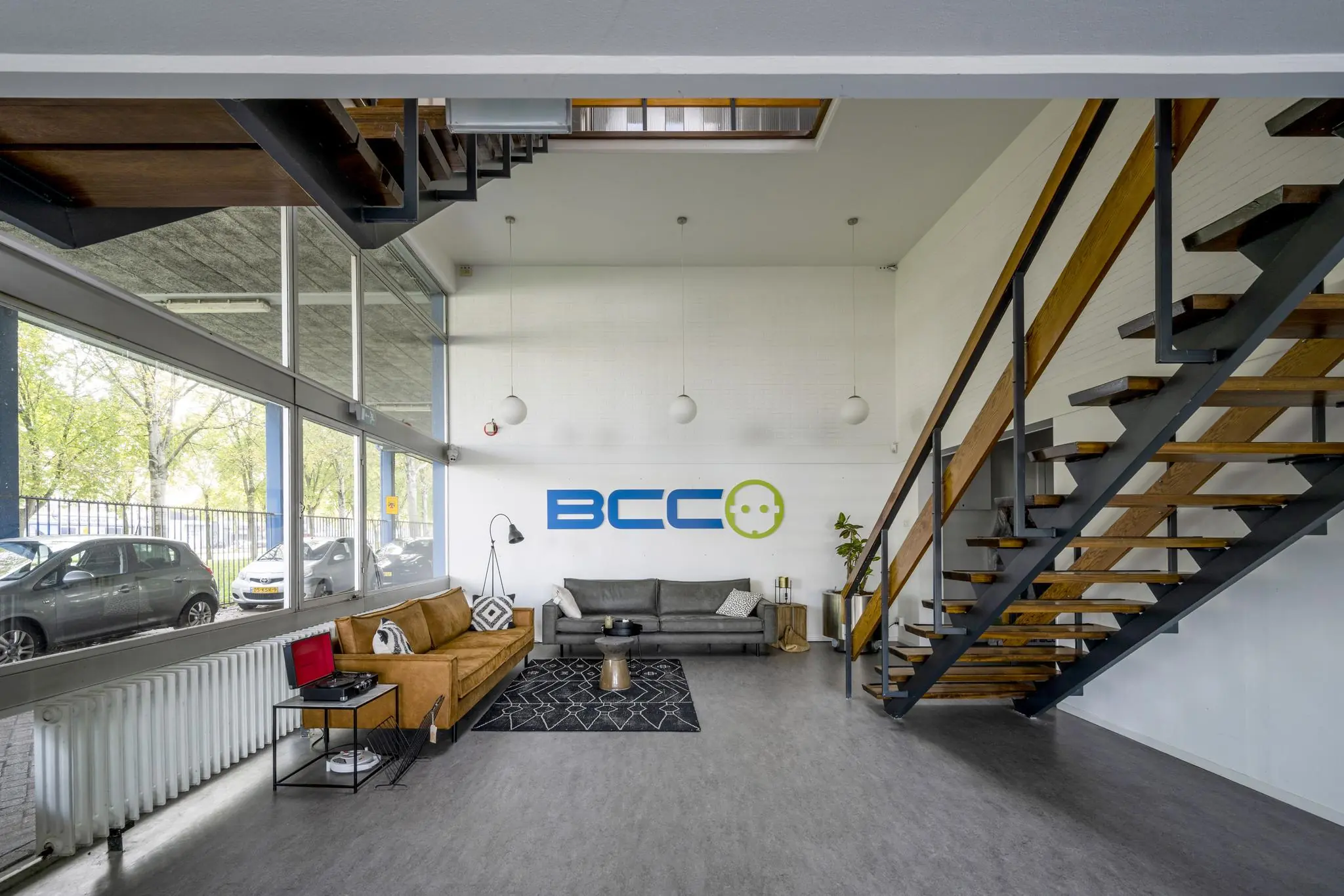 Moderne wachtruimte met comfortabele zitbanken en het BCC-logo op de muur, gelegen aan de Van der Madeweg.