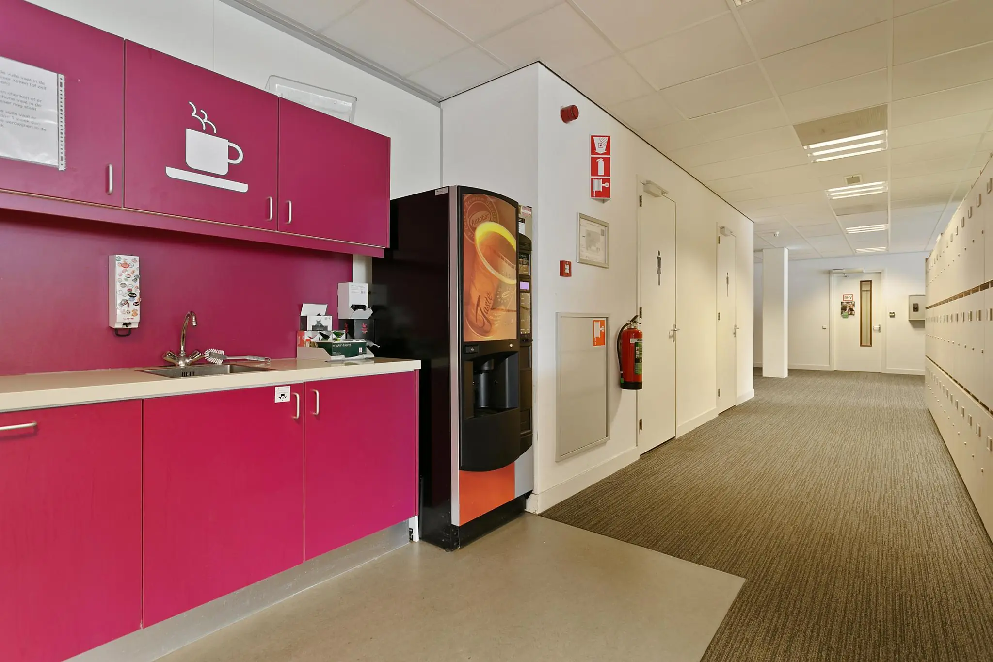 Keukenblok met paarse kastjes, koffiemachine en gootsteen in een kantoorhal aan de Dynamostraat.