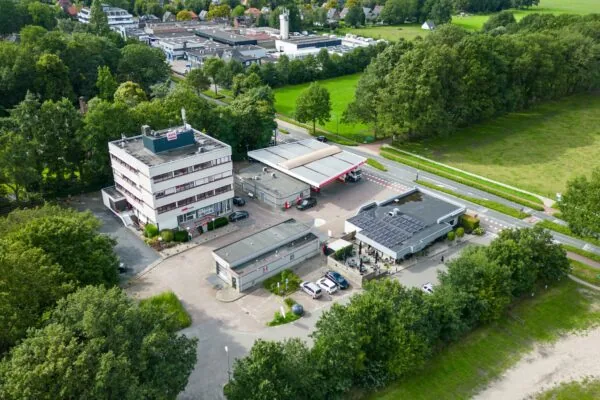 Luchtfoto van een AVIA tankstation aan de Birkstraat met omliggende gebouwen en groene omgeving.