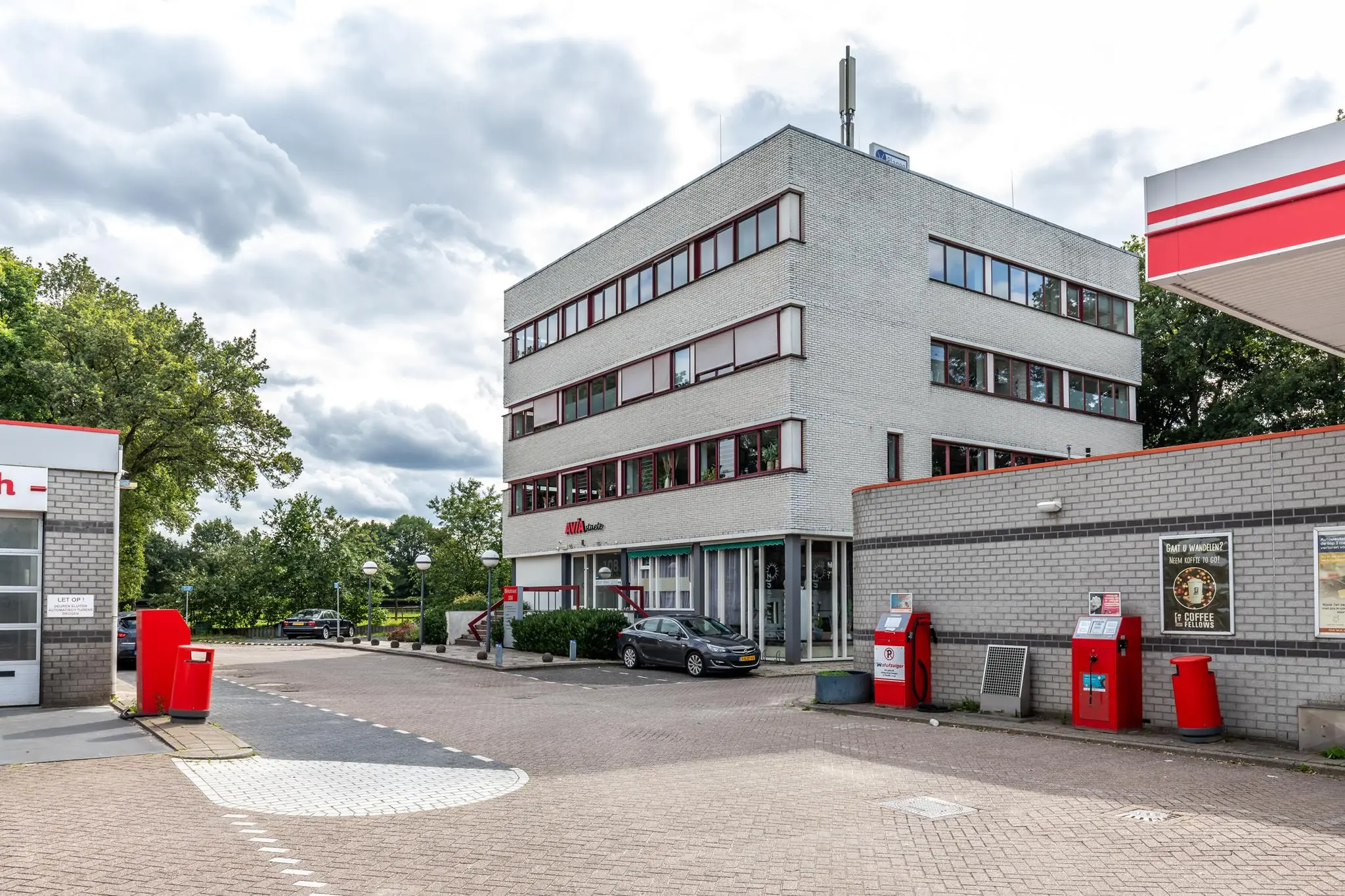 Kantoorgebouw aan de Birkstraat naast een AVIA-tankstation met rode pompinstallaties.