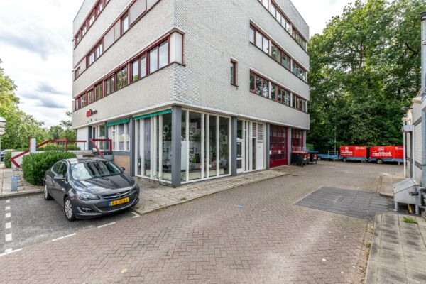 Hoekpand aan de Birkstraat met geparkeerde auto en rode afvalcontainers van Multibak op de achtergrond.