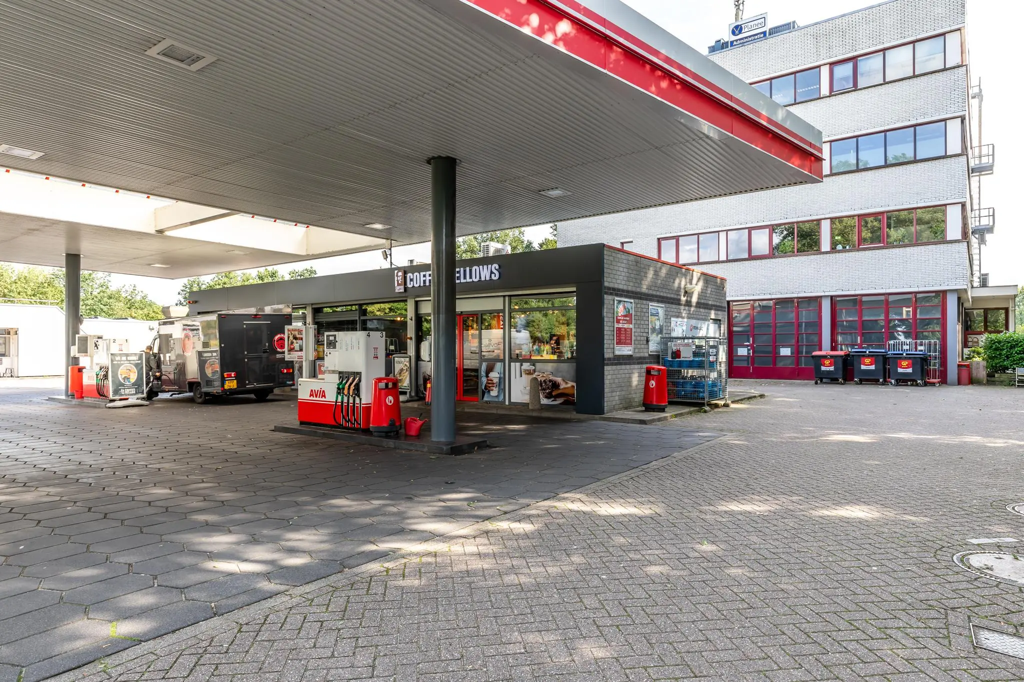 Tankstation aan de Birkstraat met AVIA pompen en Coffee Fellows shop naast een modern kantoorgebouw.