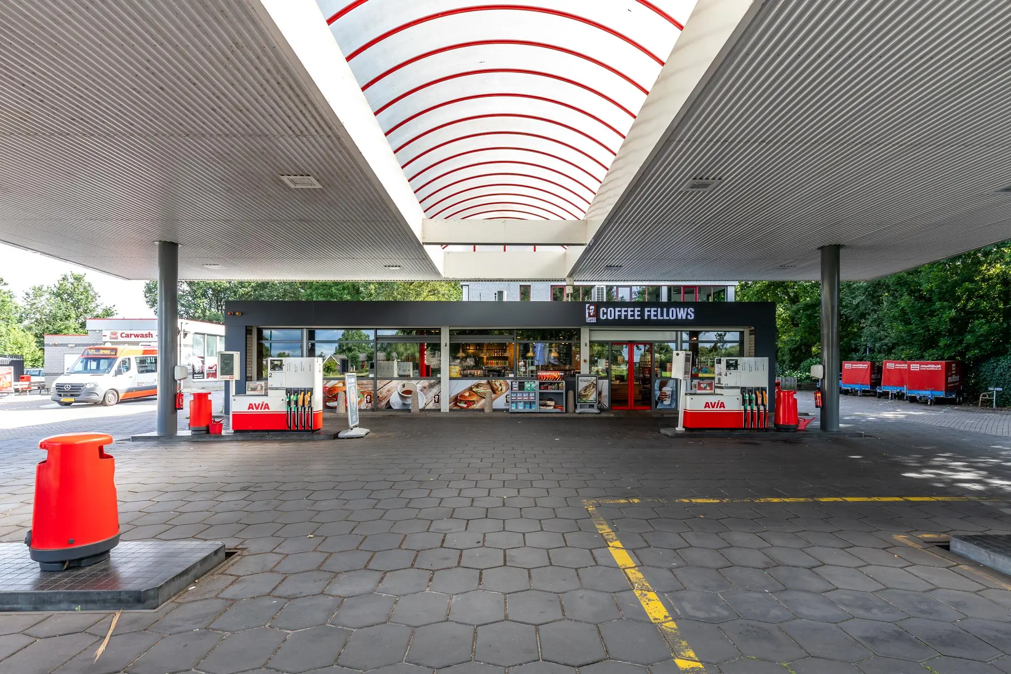 Tankstation AVIA aan de Birkstraat met overkapping, pompen en een Coffee Fellows winkel op de achtergrond.