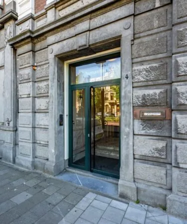 Ingang van het pand aan de Sarphatistraat 4 in Amsterdam, met opschrift “Humanitas” boven de glazen deur.