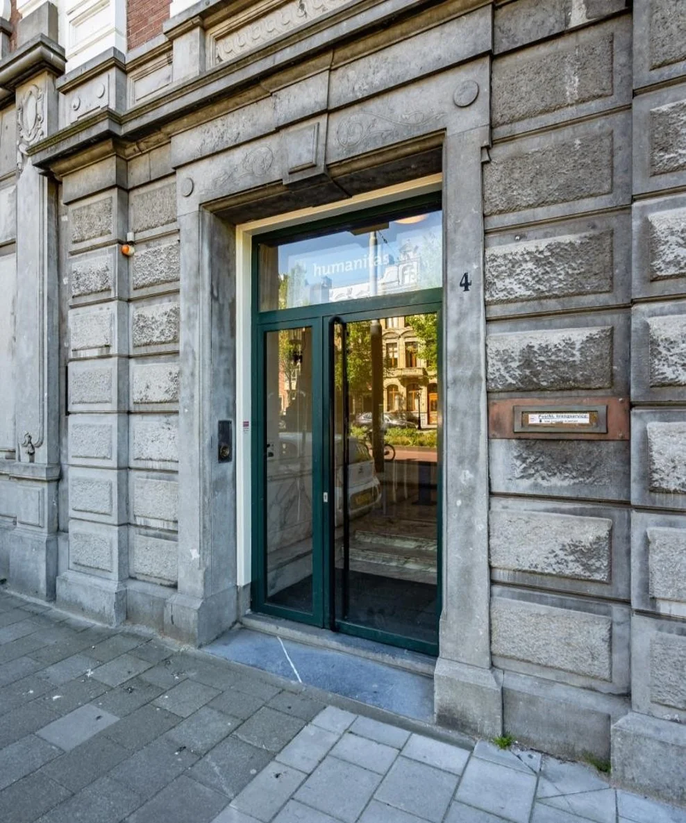 Ingang van het pand aan de Sarphatistraat 4 in Amsterdam, met opschrift “Humanitas” boven de glazen deur.