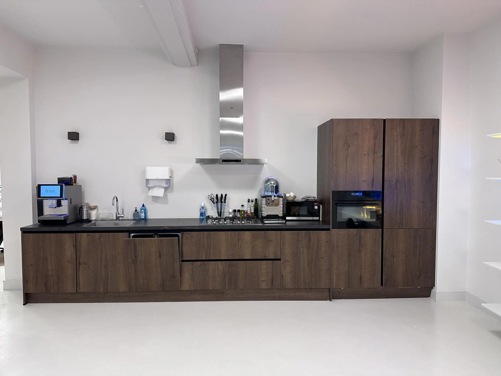 Moderne keuken met donkerhouten kasten, ingebouwde apparaten en een koffieautomaat aan de Bloemgracht.