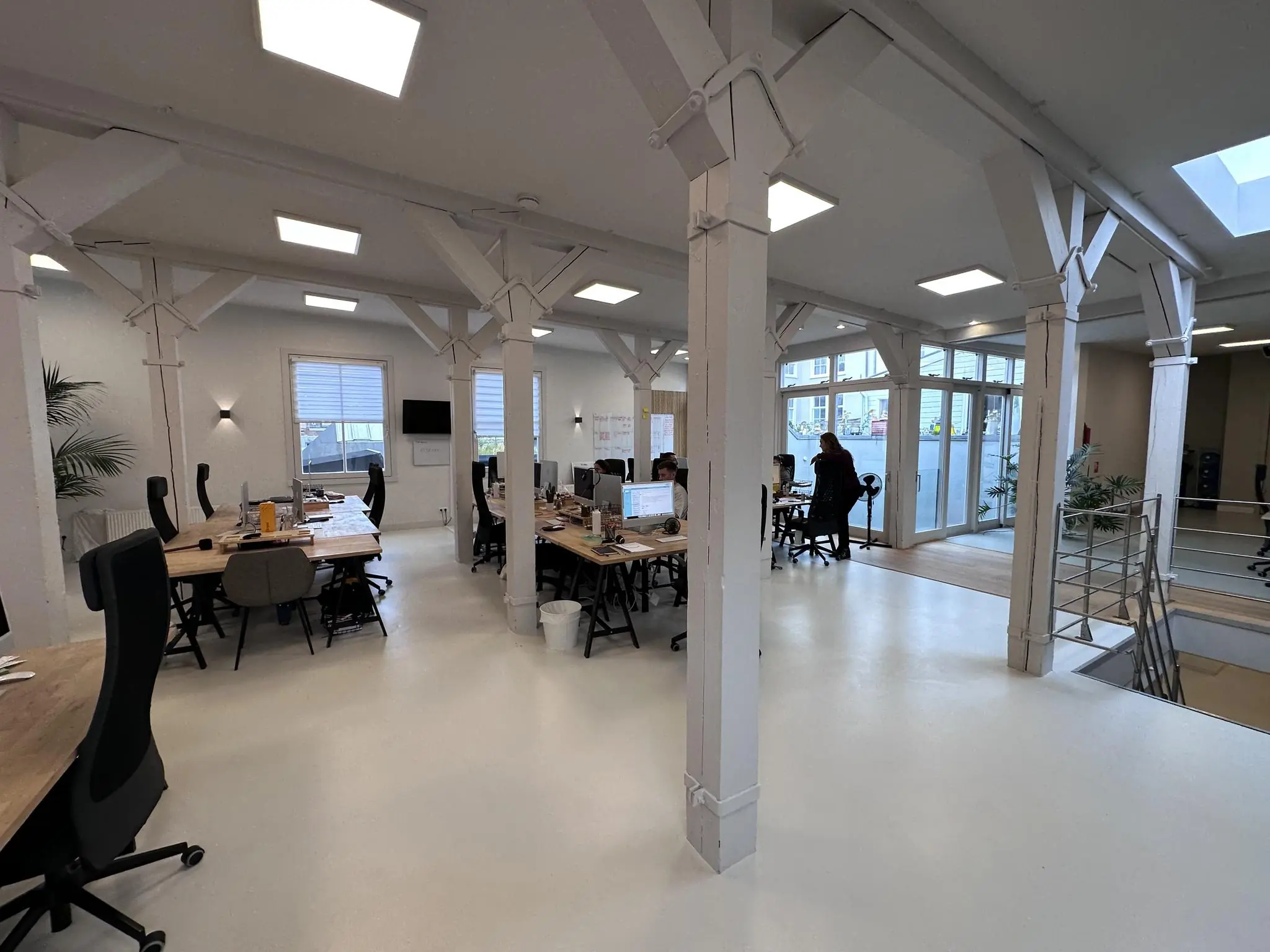 Modern kantoorinterieur aan de Bloemgracht met open werkplekken, witte muren en houten details.