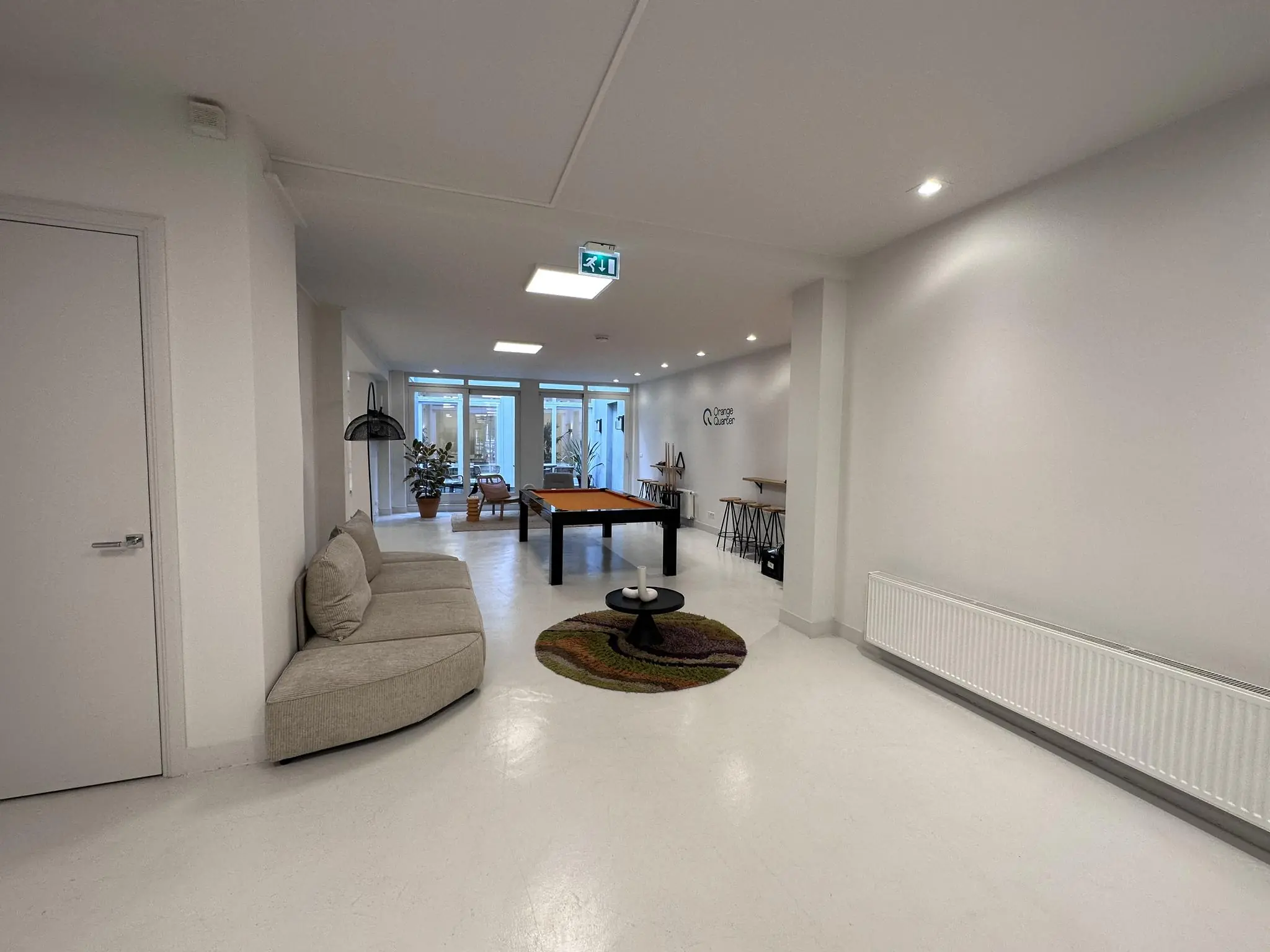 Moderne, lichte gemeenschappelijke ruimte aan de Bloemgracht met zithoek, biljarttafel en werkplekken.