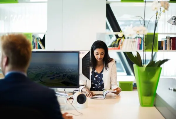 Vrouw leest een tijdschrift aan een modern bureau op een kantoor aan de Orteliuslaan.
