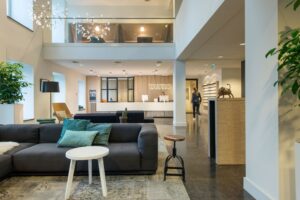 Moderne en stijlvolle ontvangsthal van een kantoorruimte aan de Koninginnegracht 19 in Den Haag met loungehoek en receptiebalie van TAURO.