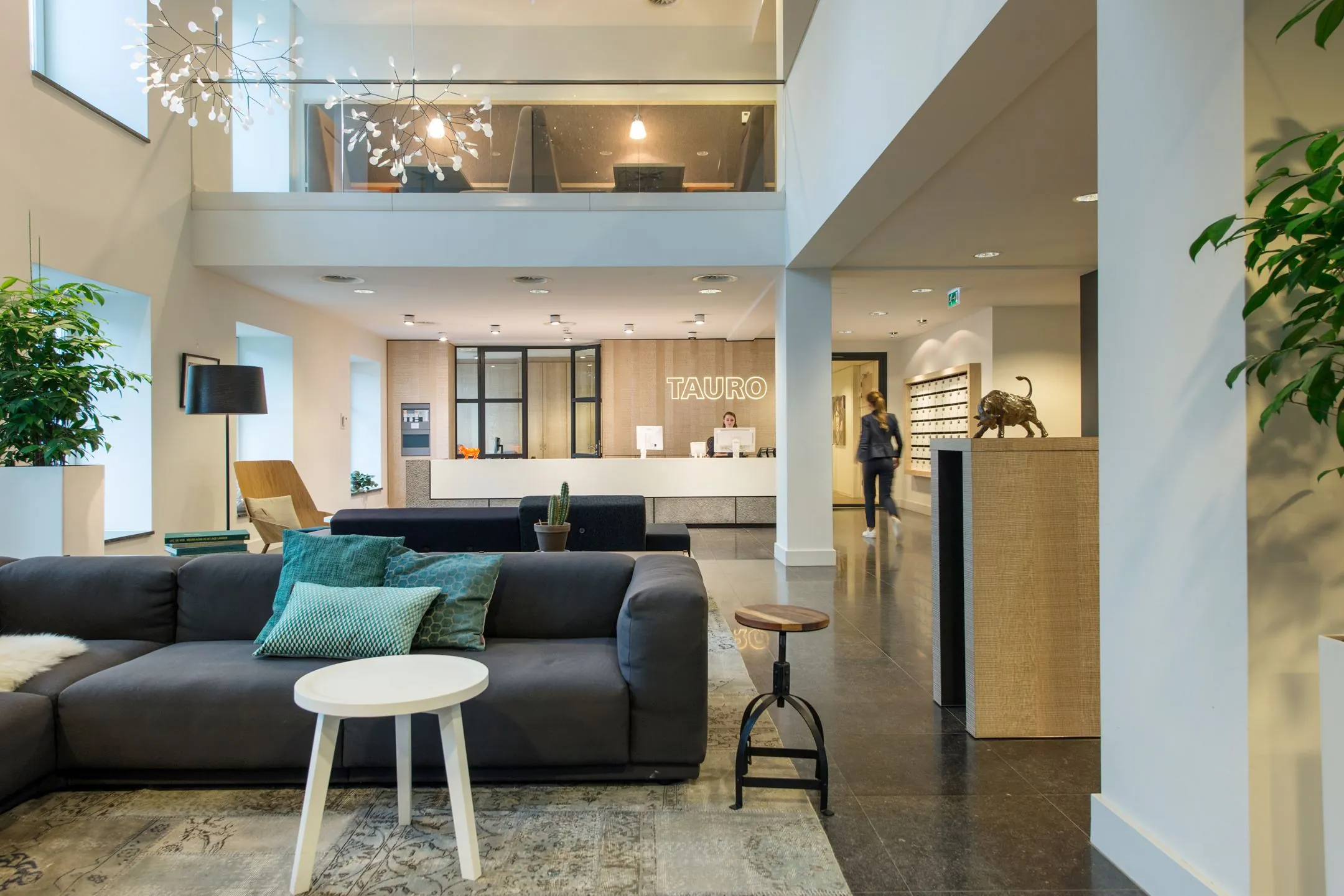 Moderne en stijlvolle ontvangsthal van een kantoorruimte aan de Koninginnegracht 19 in Den Haag met loungehoek en receptiebalie van TAURO.