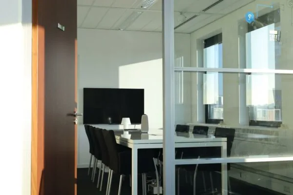 Vergaderruimte Radarweg met een lange tafel, zwarte stoelen en een groot scherm aan de muur.