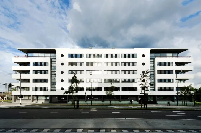 Modern wit appartementencomplex aan de Radarweg met zes verdiepingen en symmetrisch gevelontwerp.