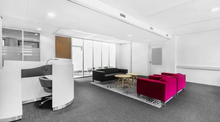 Moderne kantoorruimte aan de Paterswoldseweg met kleurrijke zithoeken en een glazen vergaderruimte.