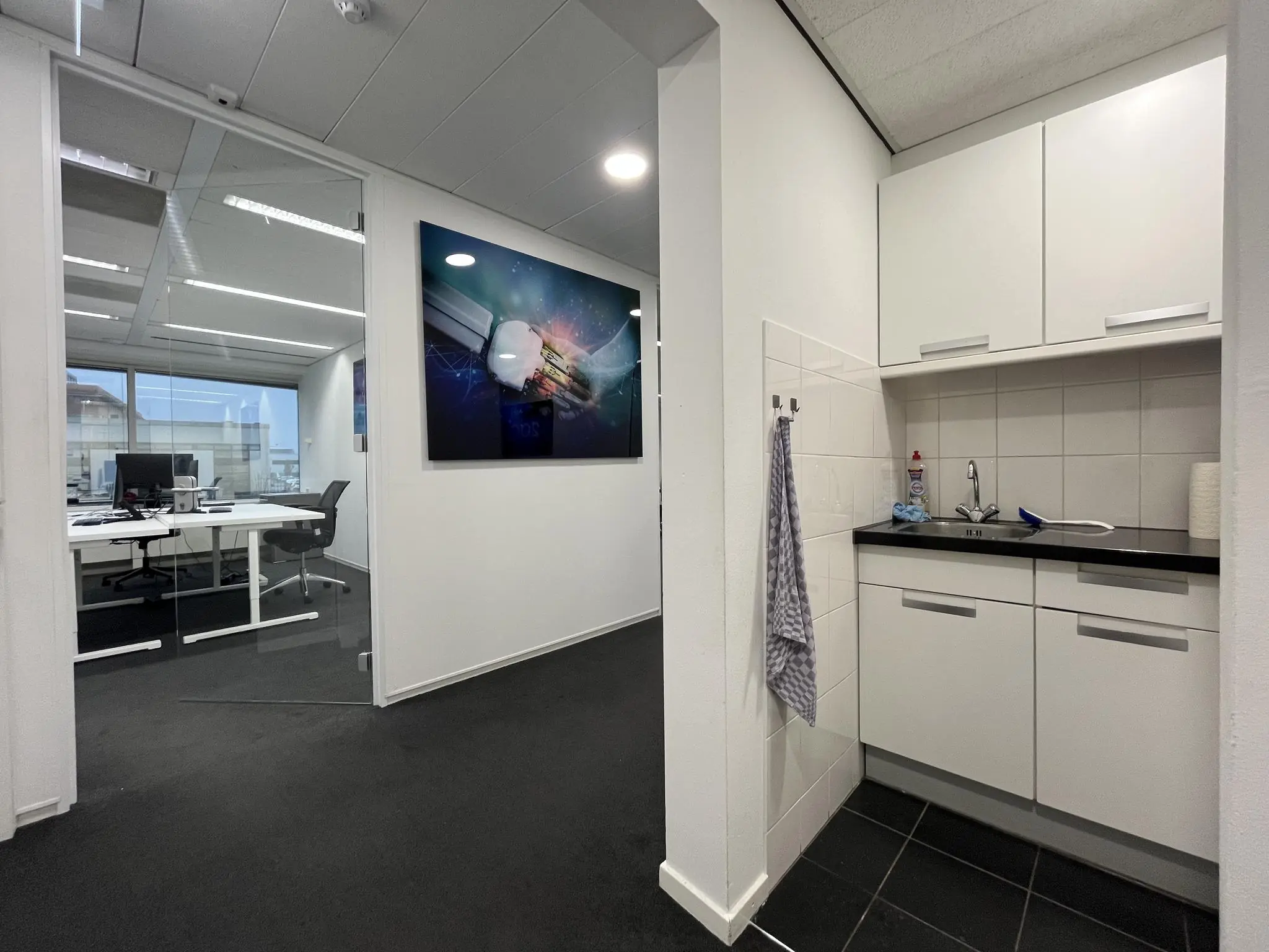 Modern kantoorinterieur met een glazen vergaderruimte en een compacte kitchenette aan de Savannahweg.