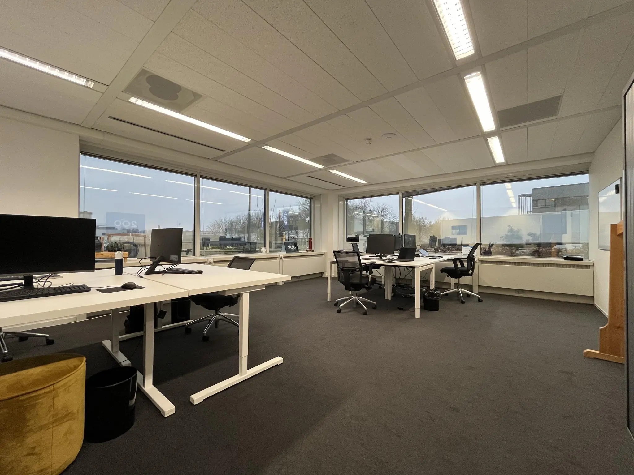 Moderne, lichte kantoorruimte aan de Savannahweg met meerdere werkplekken en grote ramen.