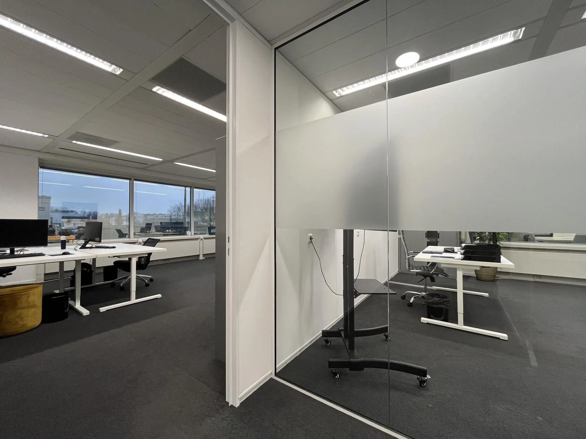 Moderne kantoorruimte aan de Savannahweg met werkplekken, grote ramen en glazen wanden.