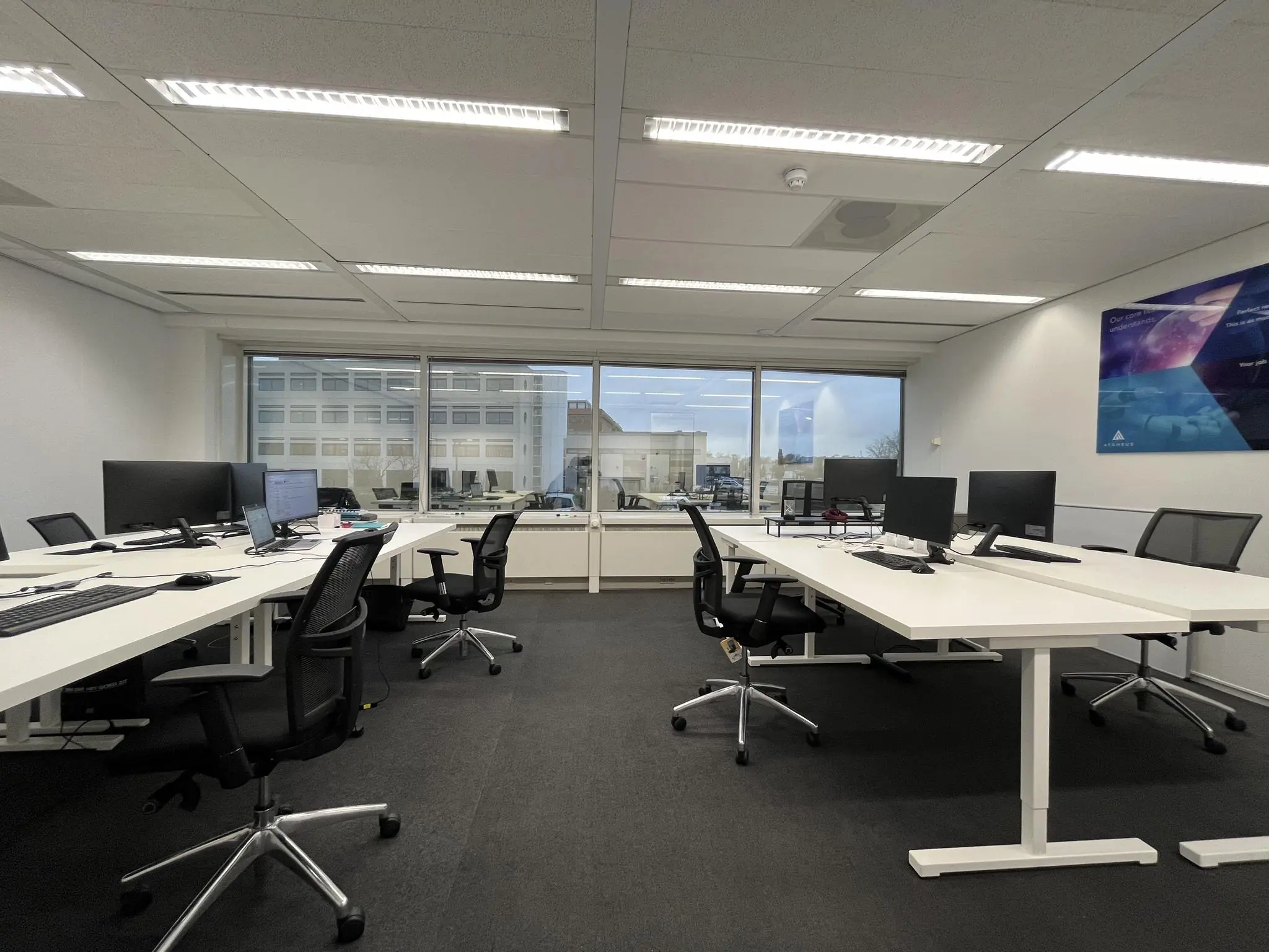 Moderne kantooruimte aan de Savannahweg met bureaus, bureaustoelen en computerschermen in een open werkopstelling.