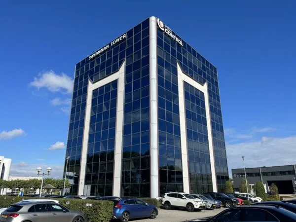 Kantoorgebouw Savannah Tower met glazen gevel en geparkeerde auto's op de voorgrond.