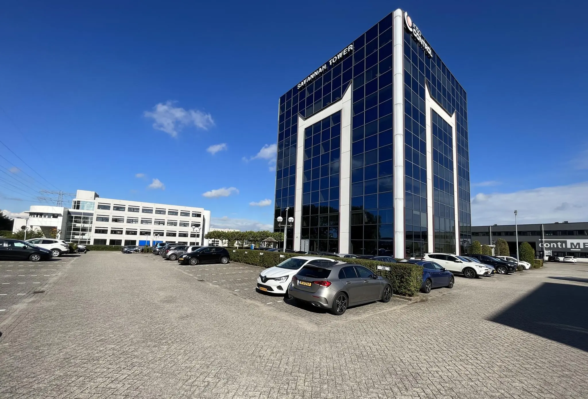 Kantoorgebouw Savannah Tower met parkeerterrein op een zonnige dag aan de Savannahweg.