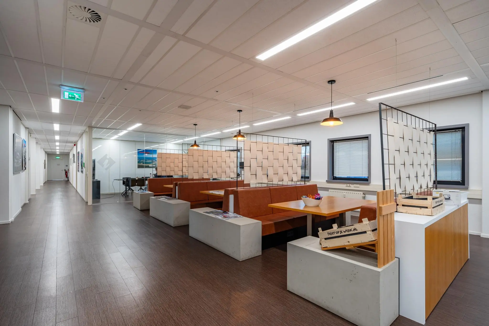 Moderne kantoorruimte aan de Barbizonlaan met zithoeken, houten accenten en decoratieve scheidingswanden.