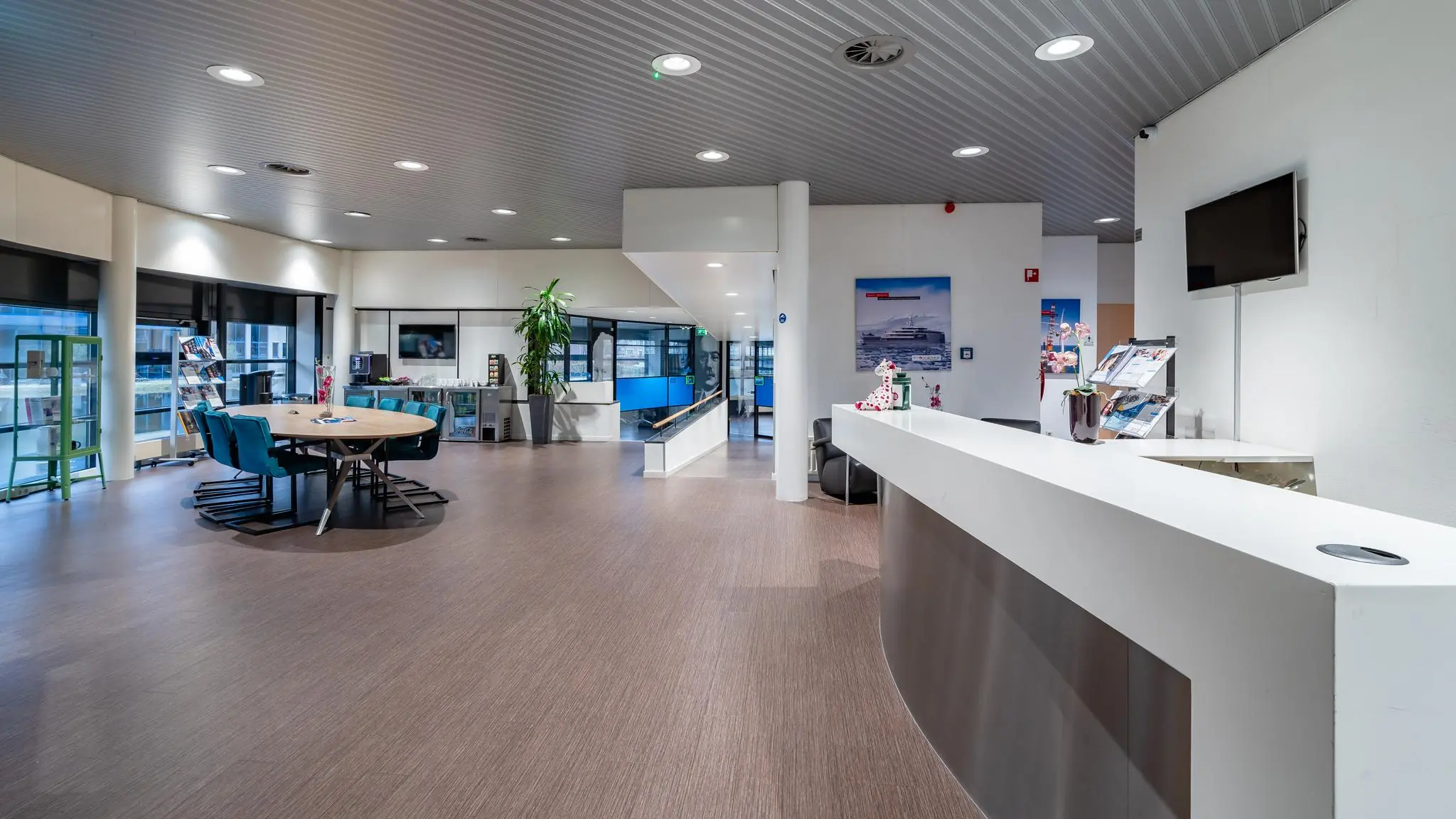 Moderne en ruim opgezette ontvangsthal aan de Barbizonlaan met balie, wachtruimte en vergadertafel.