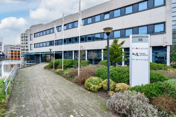 Vooraanzicht van een kantoorgebouw aan de Barbizonlaan 55 met bord van Promened en de Dopingautoriteit.