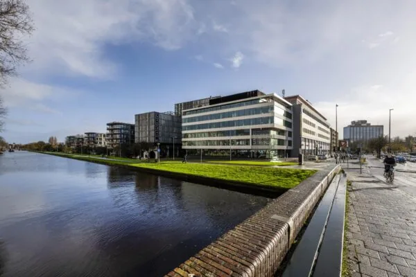 Kantoorpanden en hotel Casa aan de Wibautstraat in Amsterdam, gelegen langs een breed kanaal.