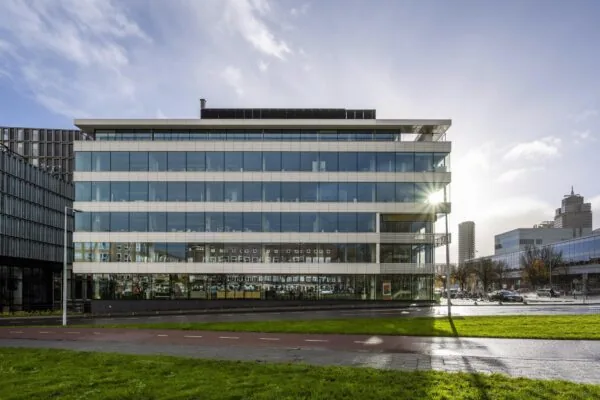 Modern kantoorgebouw aan de Wibautstraat in Amsterdam met weerspiegelende glazen gevels.