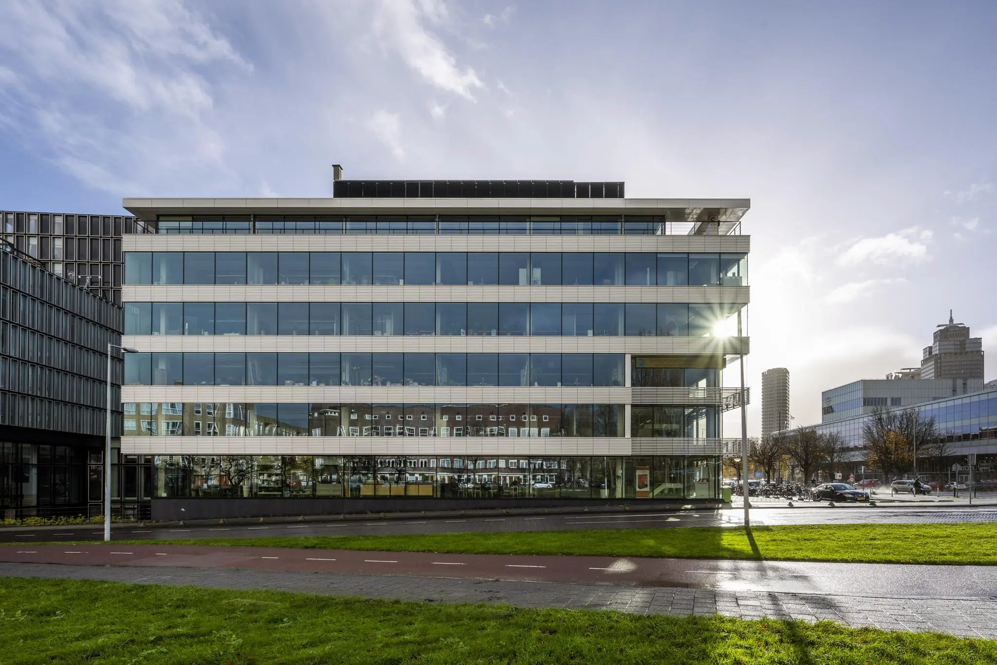 Modern kantoorgebouw aan de Wibautstraat in Amsterdam met weerspiegelende glazen gevels.