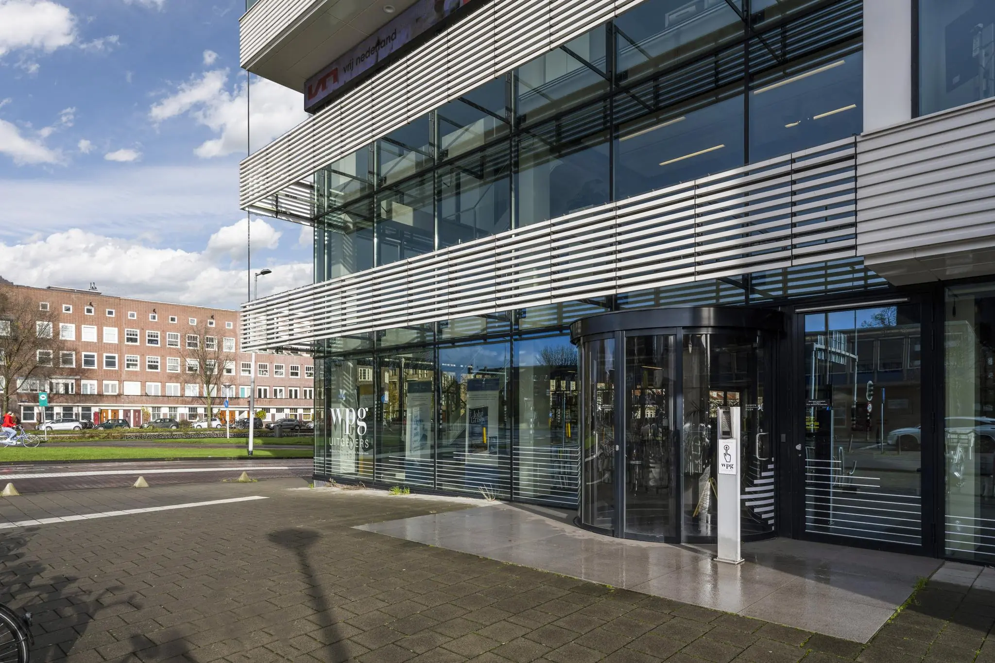Vooraanzicht van het moderne kantoorpand van WPG Uitgevers aan de Wibautstraat in Amsterdam.