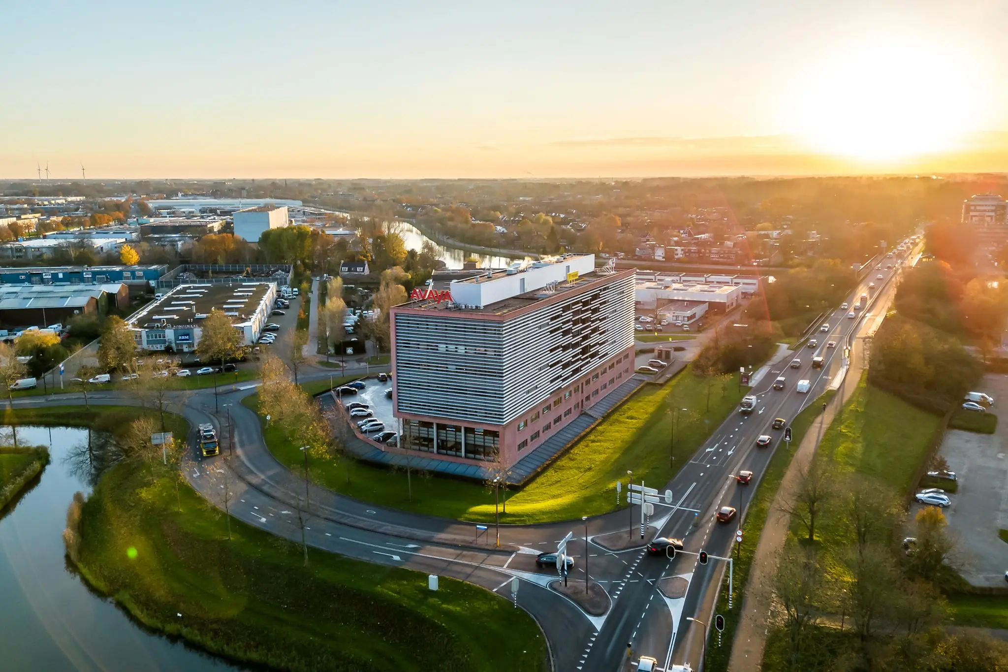 Luchtfoto van het kantoorgebouw aan de Marconibaan in Nieuwegein bij zonsondergang, met omliggende wegen en bedrijventerrein.
