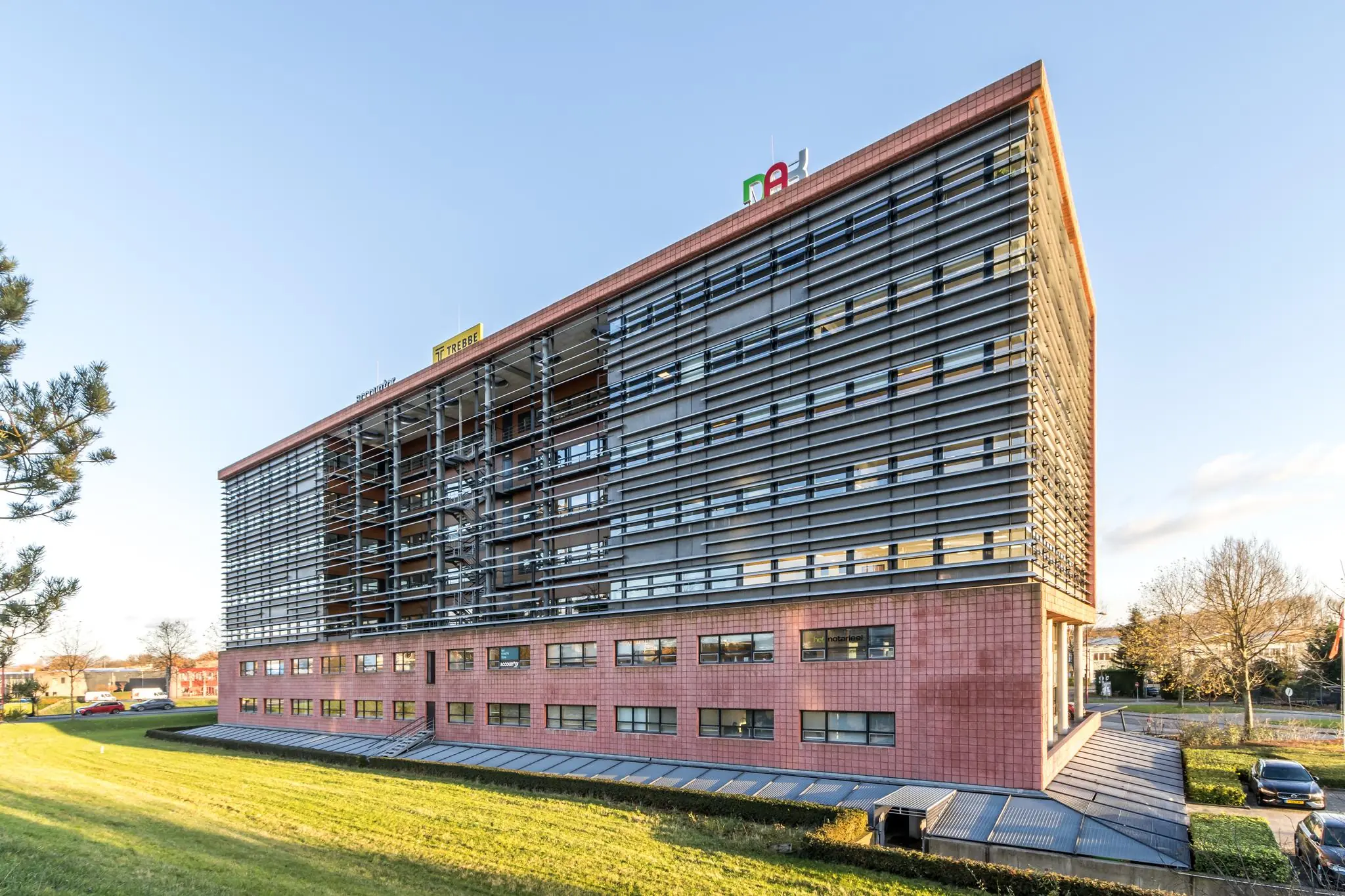 Modern kantoorgebouw aan de Marconibaan met een opvallende horizontale gevelstructuur en rode gevelpanelen.