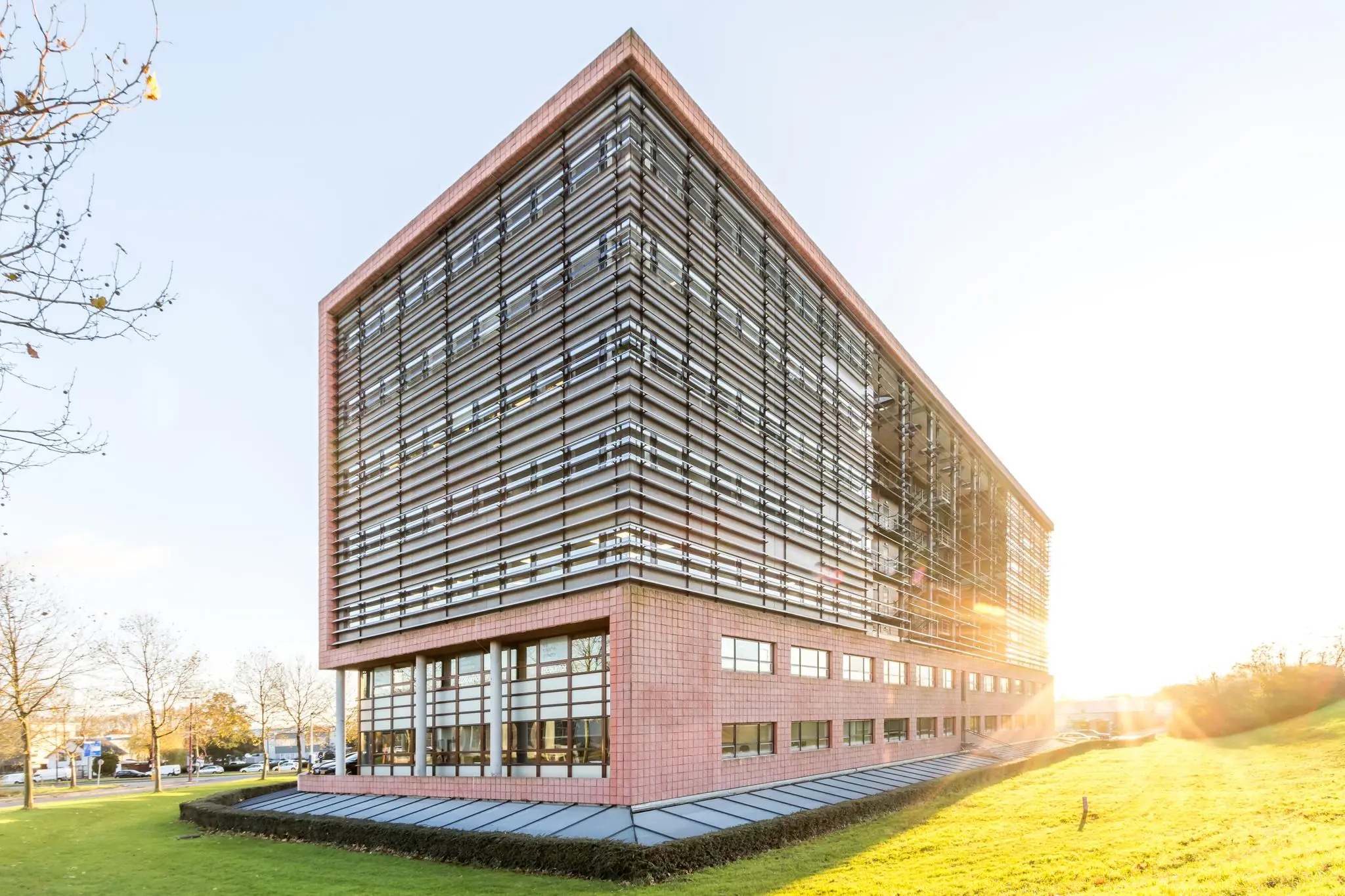 Modern kantoorgebouw aan de Marconibaan met opvallende horizontale lamellen en glazen gevel in zonlicht.