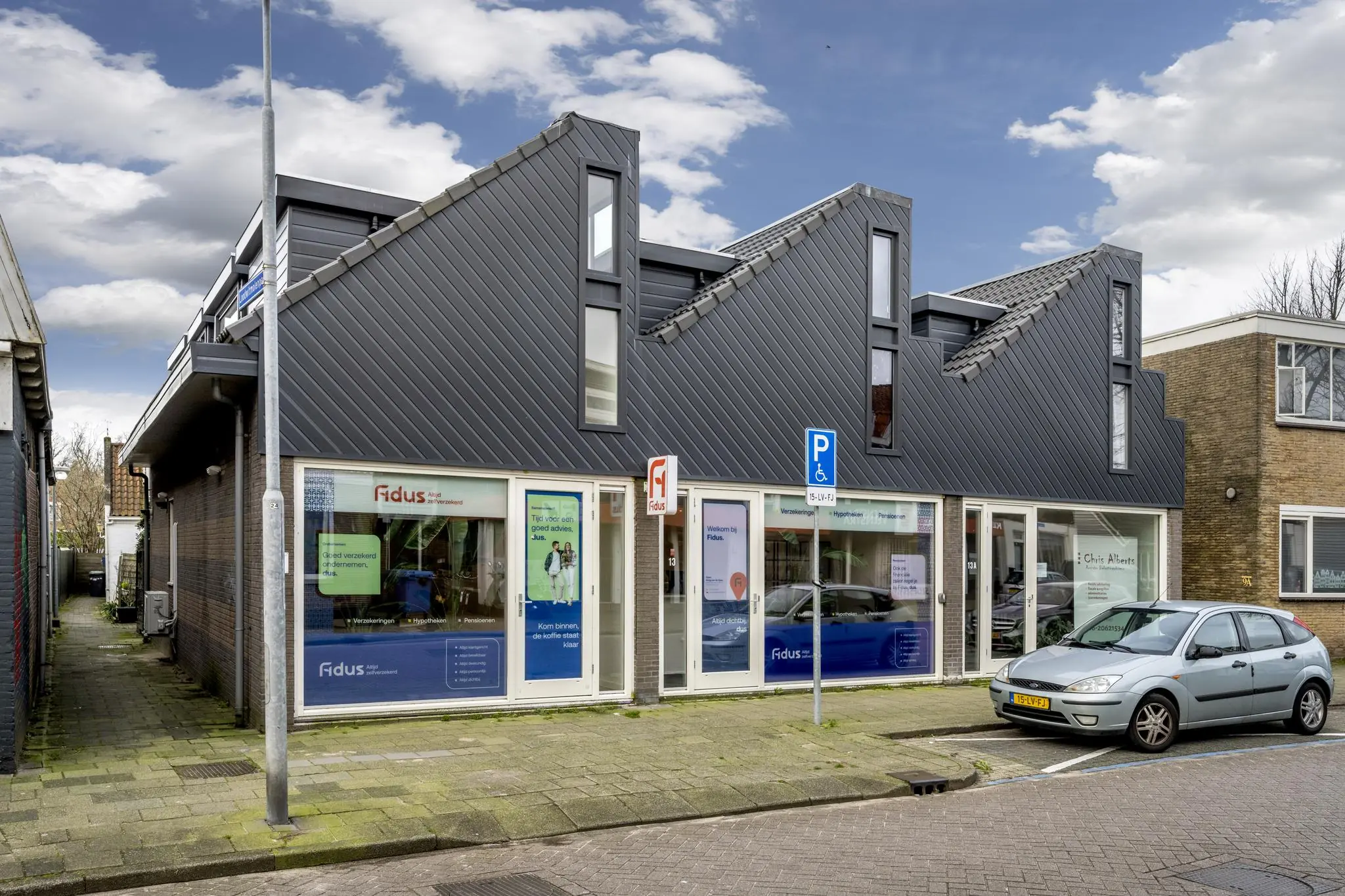 Modern kantoorpand aan de Raadhuisstraat met het kantoor van Fidus en een gehandicaptenparkeerplaats voor de deur.