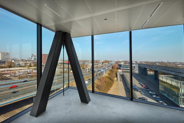 Uitzicht vanuit een modern kantoorpand aan de Joan Muyskenweg op de snelweg en omliggende gebouwen in Amsterdam.