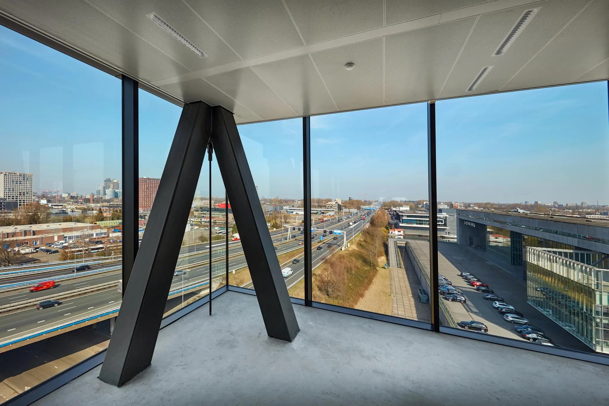 Uitzicht vanuit een modern kantoorpand aan de Joan Muyskenweg op de snelweg en omliggende gebouwen in Amsterdam.