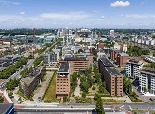 Luchtfoto van kantoren en hoogbouw aan de Hullenbergweg in Amsterdam-Zuidoost met de Johan Cruijff ArenA op de achtergrond.