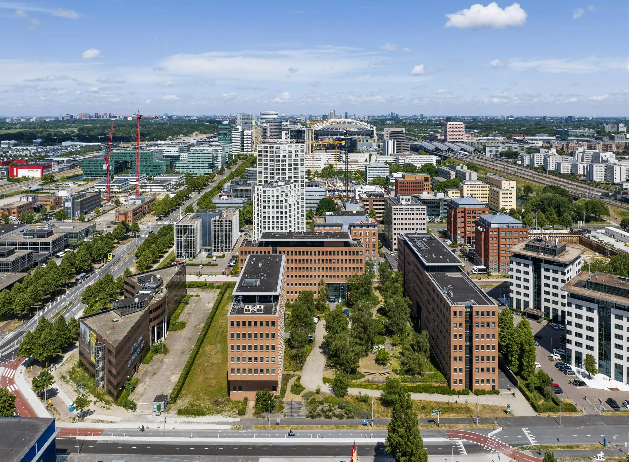 Luchtfoto van kantoren en hoogbouw aan de Hullenbergweg in Amsterdam-Zuidoost met de Johan Cruijff ArenA op de achtergrond.