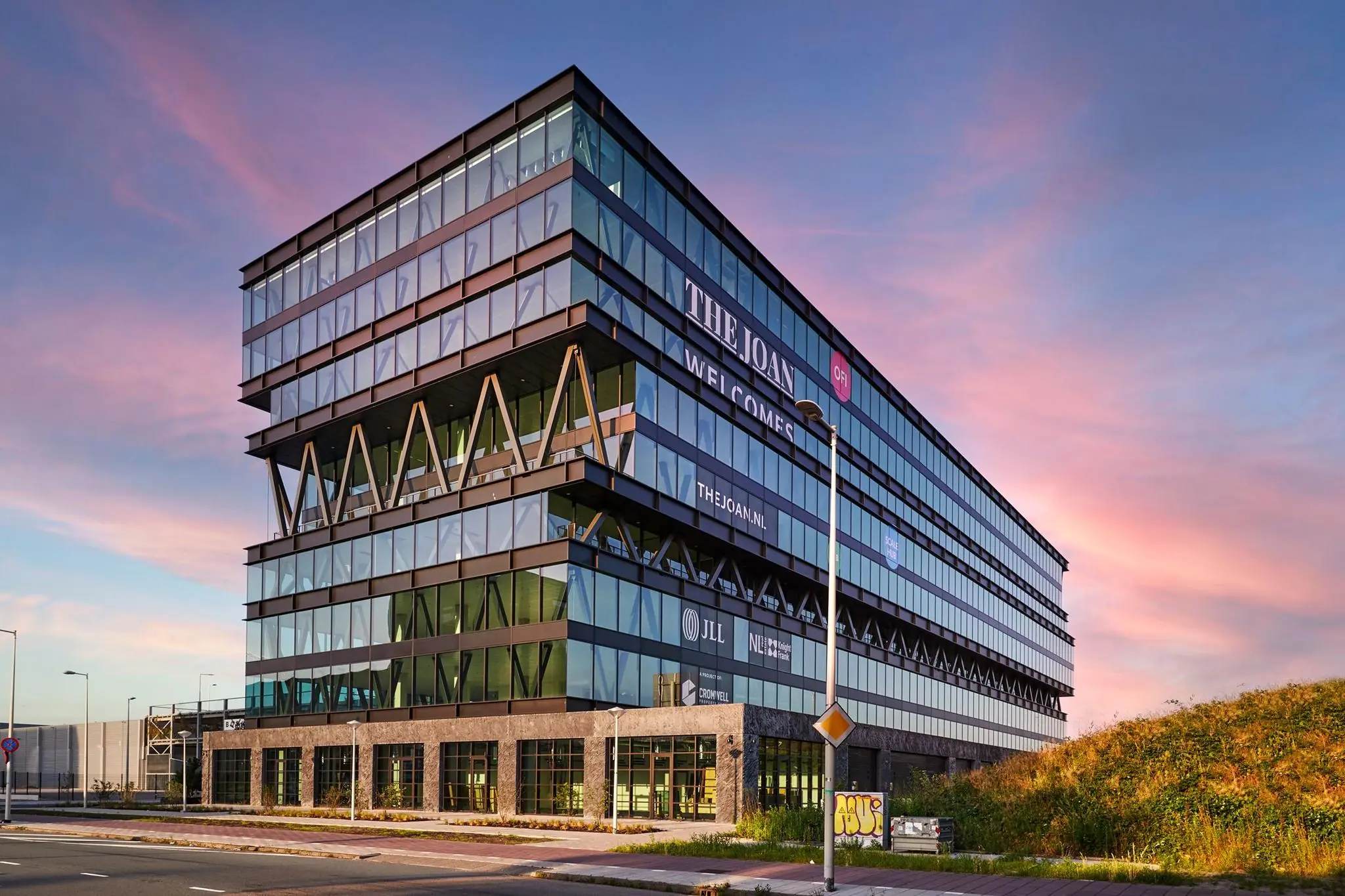 Modern kantoorgebouw 'The Joan' aan de Joan Muyskenweg in Amsterdam bij zonsondergang.