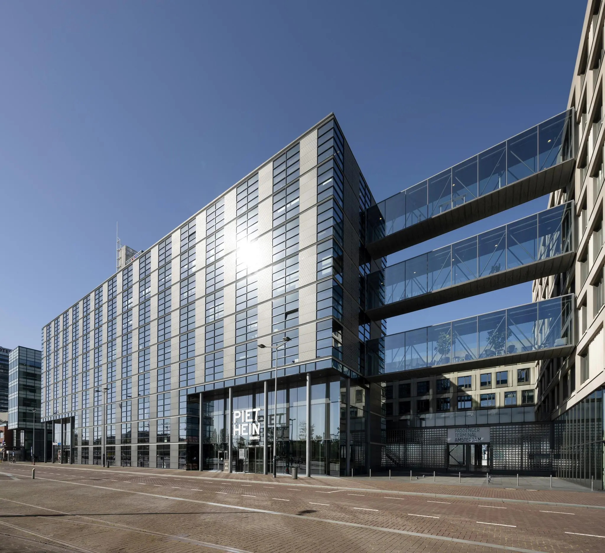 Modern kantoorgebouw aan de Piet Heinkade in Amsterdam met glazen loopbruggen tussen twee gebouwen.