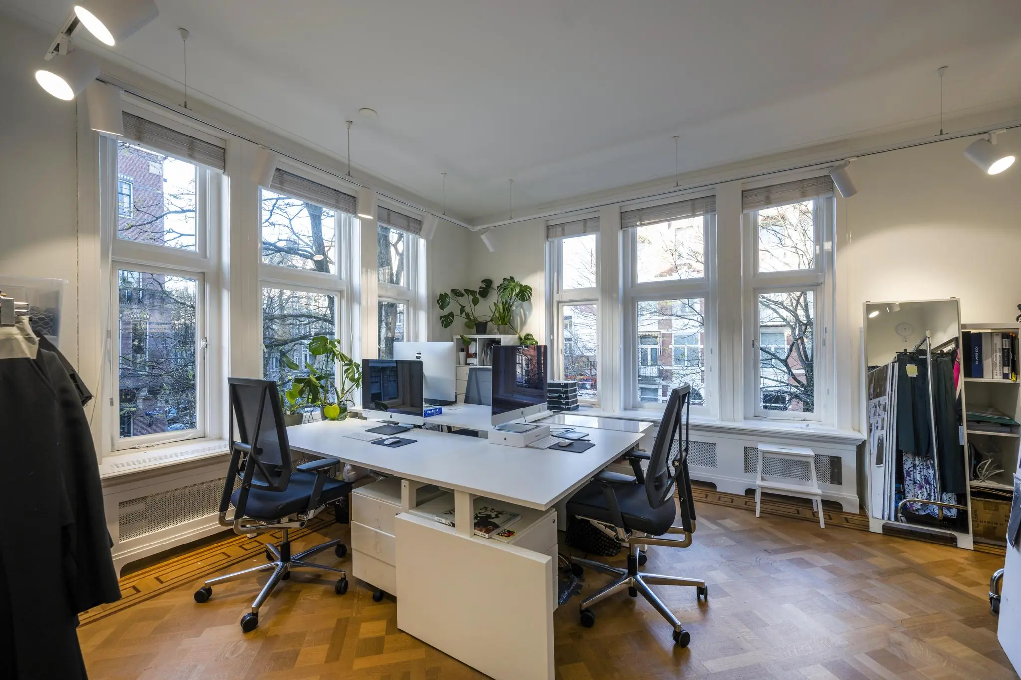 Licht en modern kantoor op de Honthorststraat met grote ramen, designbureaus en ergonomische bureaustoelen.