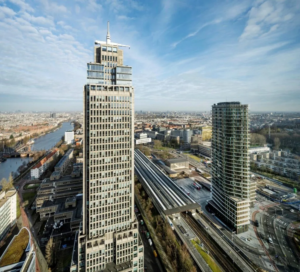 Luchtfoto van Amstelplein in Amsterdam met hoge kantoorgebouwen en het Amstelstation op de voorgrond.