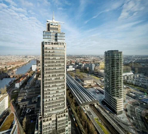Luchtfoto van Amstelplein in Amsterdam met hoge kantoorgebouwen en het Amstelstation op de voorgrond.