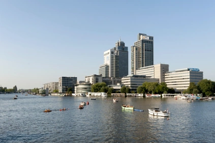 Zicht op de kantoren aan het Amstelplein in Amsterdam met boten op de rivier de Amstel.