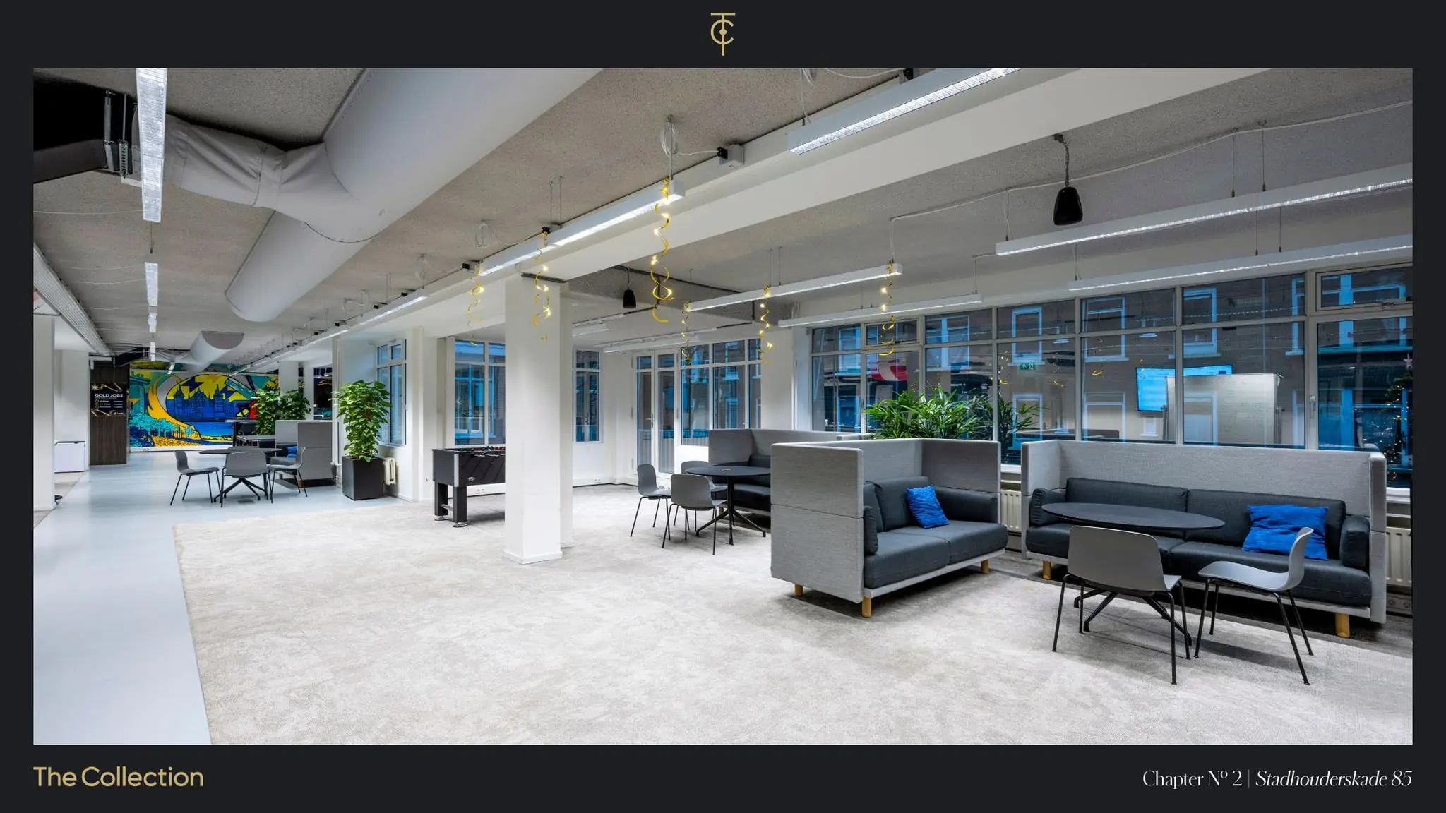 Moderne, open kantoorruimte aan de Stadhouderskade 85 met zitgedeeltes, veel daglicht en kleurrijke muurschildering.