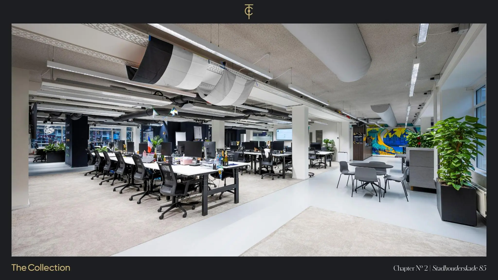 Moderne en open kantoorruimte aan de Stadhouderskade 85 met werkplekken, vergadertafel en kleurrijke muurschildering.