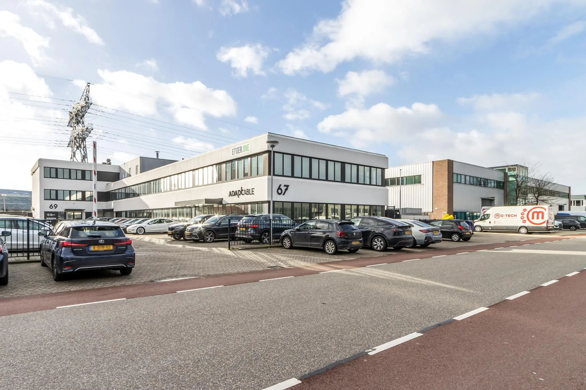 Bedrijventerrein aan de Savannahweg met kantoorgebouwen en geparkeerde auto's voor de panden met huisnummers 67 en 69.